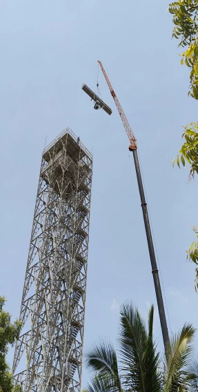 Lattice steel RADAR tower being erected by crane